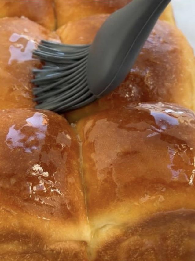 Pan brioche recién horneado barnizado con mantequilla